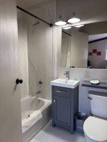 Contemporary bathroom with bathtub, sink, and mirror at Hotel LaBonte.