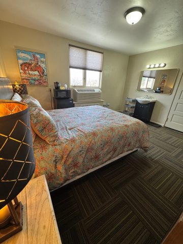 Comfortable queen room with floral bedding and modern amenities in Douglas, WY.