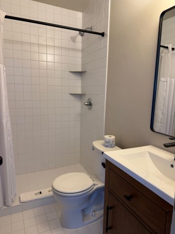 Clean bathroom with shower, toilet, and vanity at Hotel LaBonte.