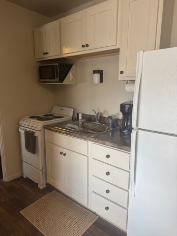 Cozy kitchen at Hotel LaBonte in Douglas Wyoming with stove and refrigerator.