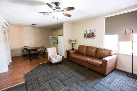 Comfortable living area in Douglas, WY hotel suite with sofa and dining space.