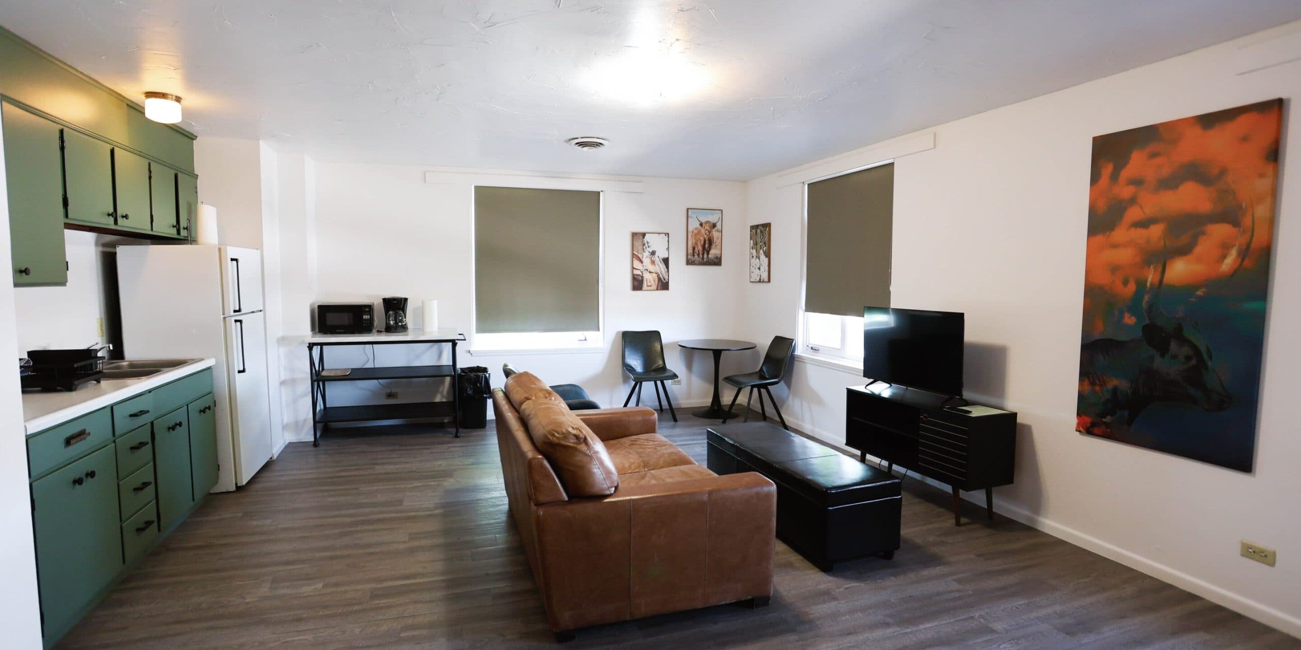 Spacious hotel living room with sofa, TV, and artwork in Douglas WY.