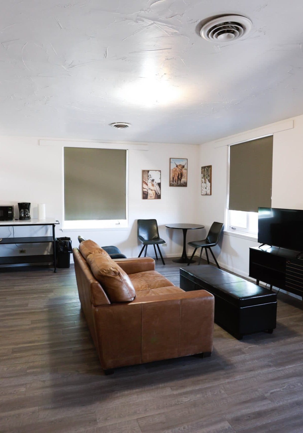 Spacious hotel living room with sofa, TV, and artwork in Douglas WY.